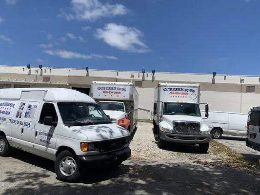 Camiones y vans reales de South Express Moving estacionados en las instalaciones de la compañía